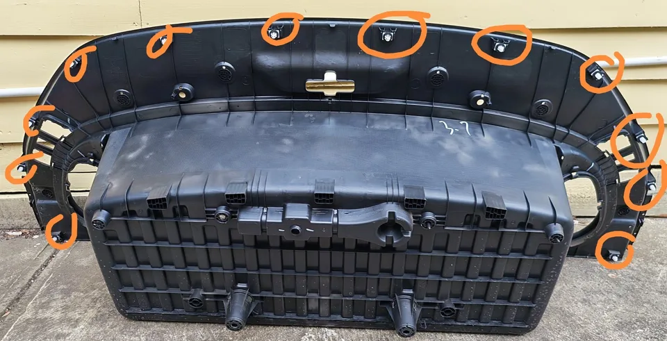 Underside of the removed front boot liner with twelve perimeter clips marked in orange