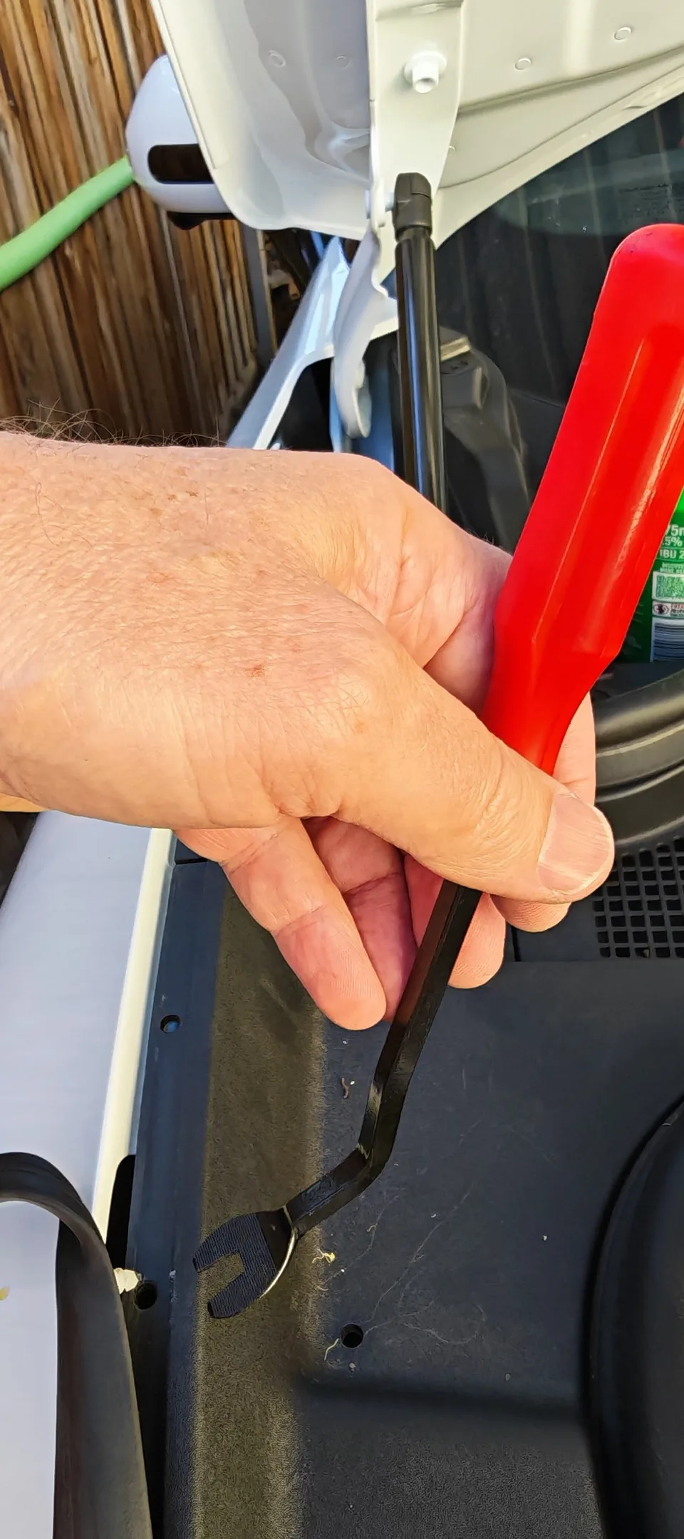 A forked trim-removal tool beside a rubber-seal retaining clip
