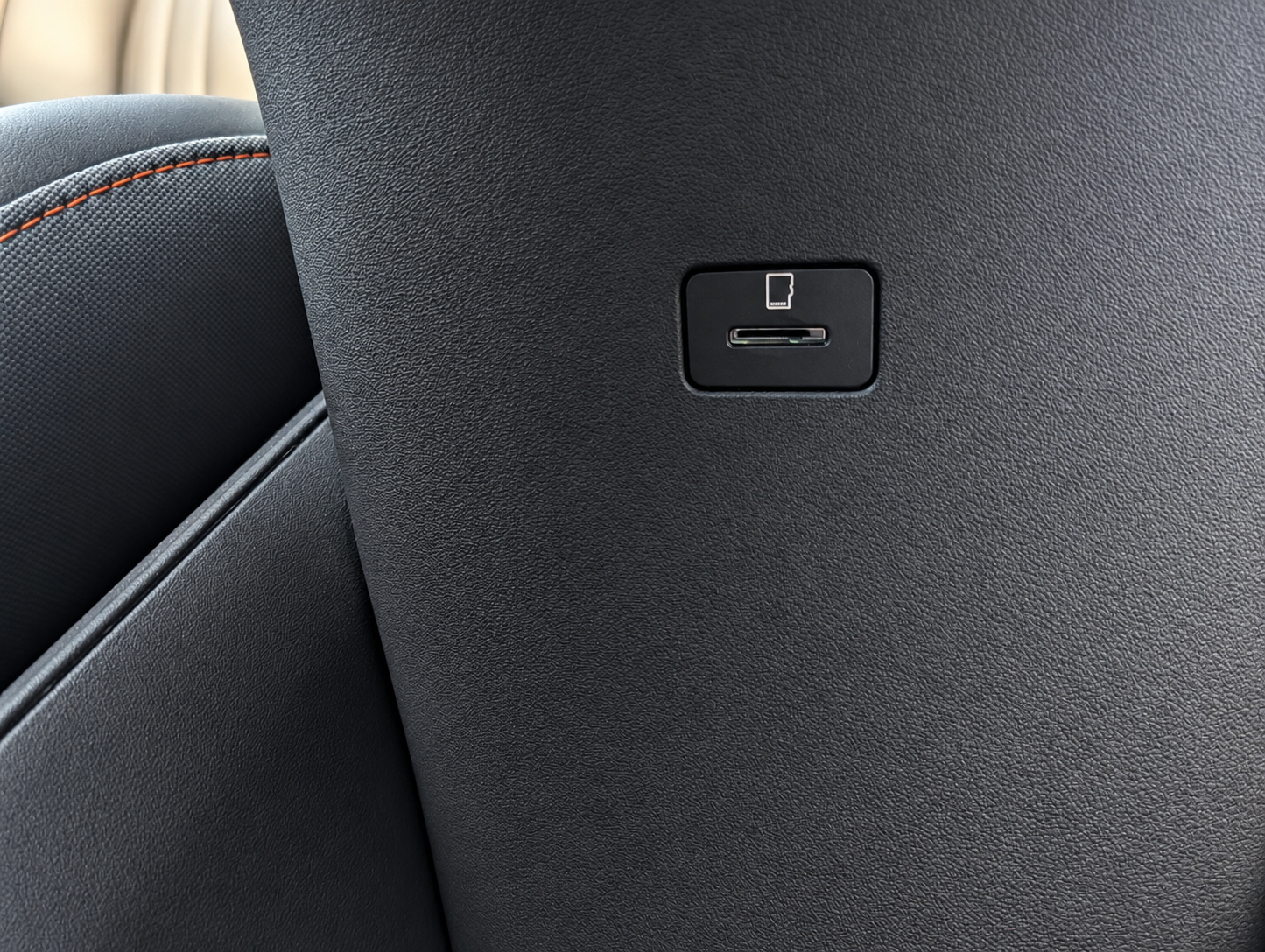Close view of the microSD card slot and symbol on the inner right wall of the centre-console storage area.
